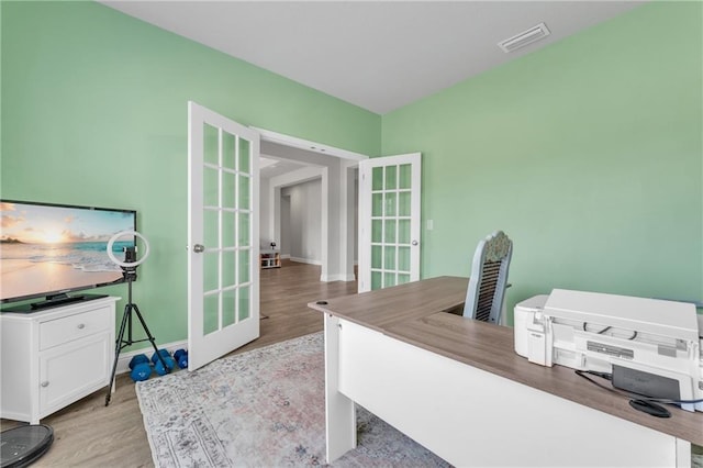 office area with french doors, visible vents, light wood-style flooring, and baseboards