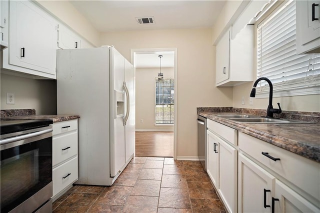 kitchen with stainless steel appliances, sink, pendant lighting, and white cabinets