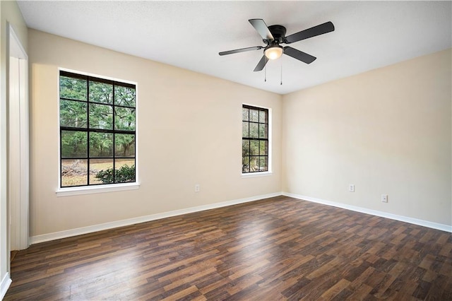 empty room with ceiling fan and dark hardwood / wood-style flooring