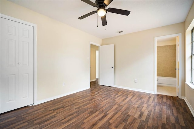 unfurnished bedroom with ceiling fan, connected bathroom, and dark hardwood / wood-style flooring