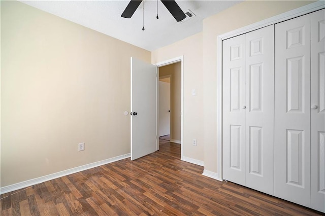 unfurnished bedroom with dark hardwood / wood-style flooring, a closet, and ceiling fan