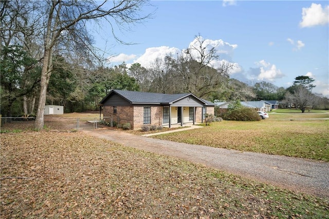 view of front facade featuring a shed, covered porch, and a front lawn