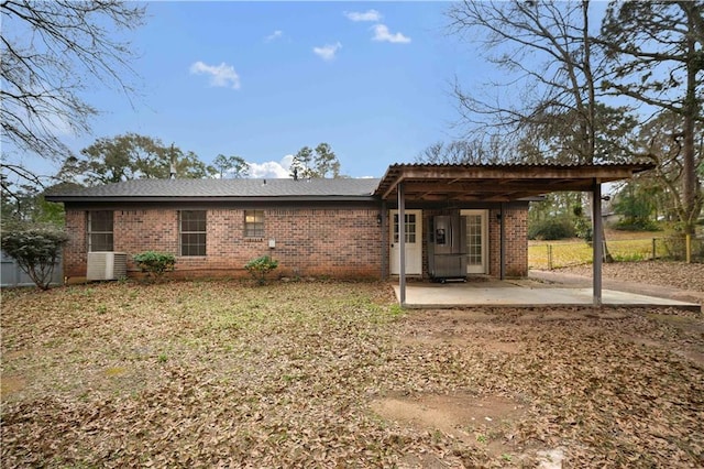 back of property with central AC unit and a patio area