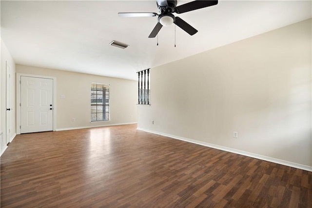 empty room with dark hardwood / wood-style floors and ceiling fan