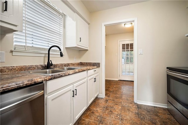 kitchen with stainless steel appliances, sink, and white cabinets