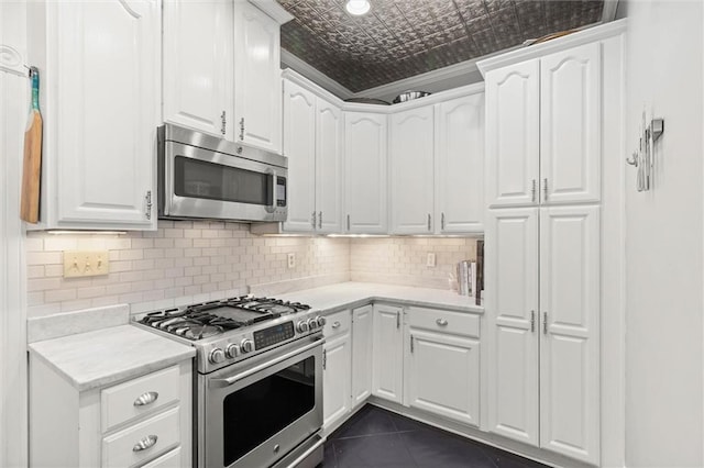 206 George St, Mobile, AL 36604 - kitchen featuring appliances with stainless steel finishes, an ornate ceiling, white cabinets, and backsplash