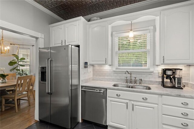 206 George St, Mobile, AL 36604 - kitchen with appliances with stainless steel finishes, a sink, an ornate ceiling, white cabinets, and ornamental molding