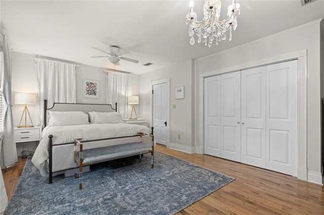 206 George St, Mobile, AL 36604 - bedroom featuring wood finished floors, a chandelier, a closet, baseboards, and a ceiling fan