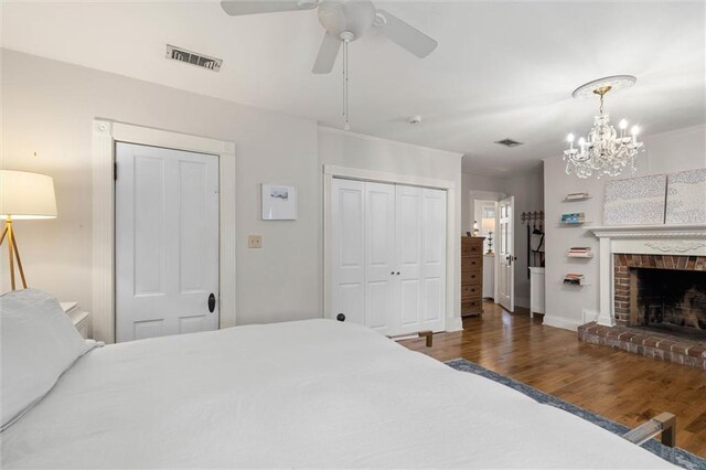 206 George St, Mobile, AL 36604 - bedroom with wood finished floors, a chandelier, a closet, a brick fireplace, and baseboards