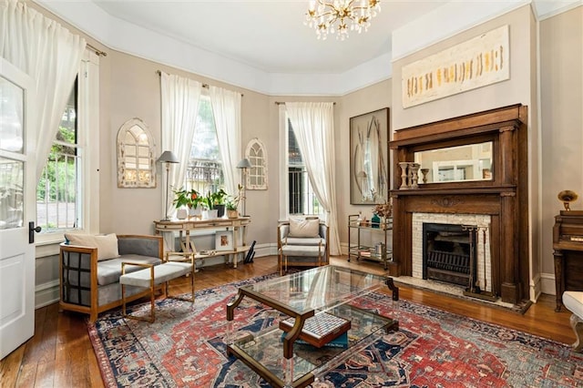 206 George St, Mobile, AL 36604 - sitting room with plenty of natural light, hardwood / wood-style flooring, a chandelier, and a stone fireplace