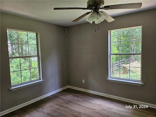 spare room featuring a textured ceiling, plenty of natural light, ceiling fan, and wood-type flooring