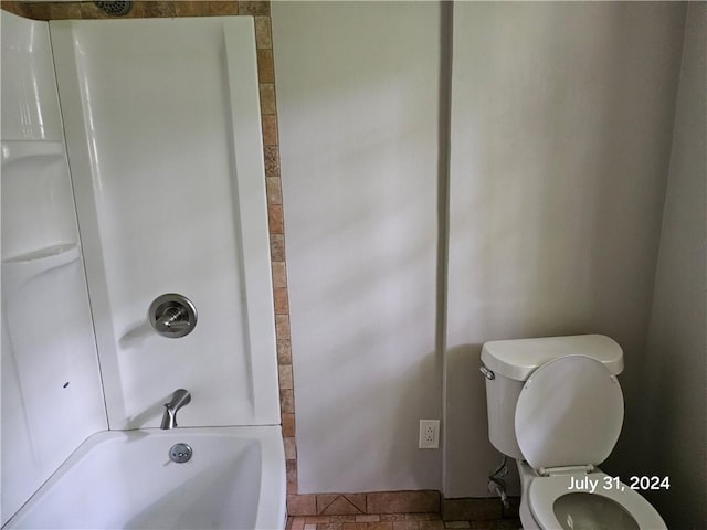 bathroom featuring tile patterned flooring, toilet, and tub / shower combination