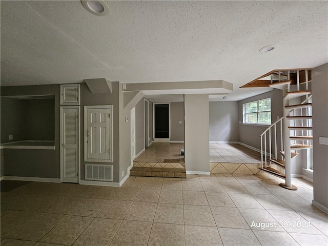 interior space featuring a textured ceiling and light tile patterned floors