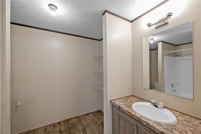 6550 Oak Grove Rd, Eight Mile, AL 36613 - bathroom with vanity, wood finished floors, a textured ceiling, toilet, and ornamental molding