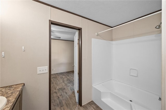 6550 Oak Grove Rd, Eight Mile, AL 36613 - bathroom with wood finished floors, bathtub / shower combination, vanity, a textured ceiling, and ornamental molding