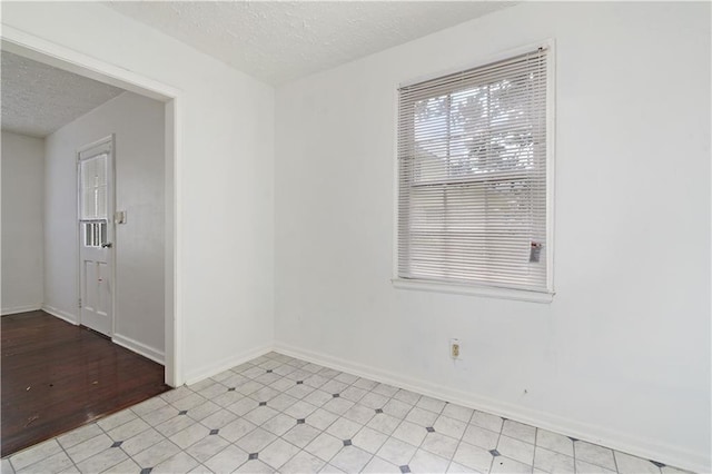 unfurnished room featuring a textured ceiling and light hardwood / wood-style floors