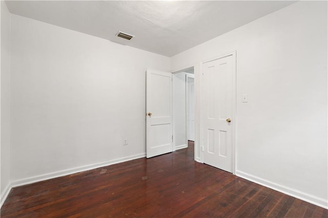 empty room with dark hardwood / wood-style flooring