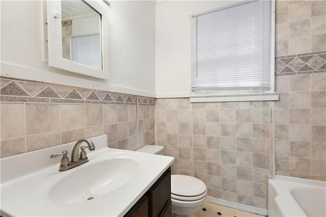 bathroom featuring vanity, tile walls, and toilet