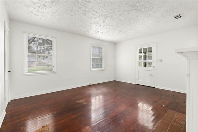 unfurnished room with dark hardwood / wood-style floors and a textured ceiling