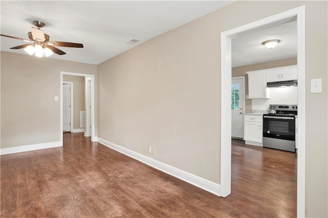 unfurnished room featuring a textured ceiling, ceiling fan, and dark wood-type flooring