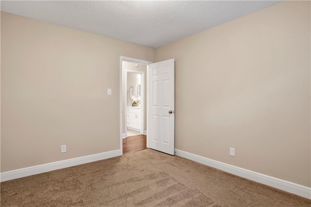 carpeted spare room with a textured ceiling