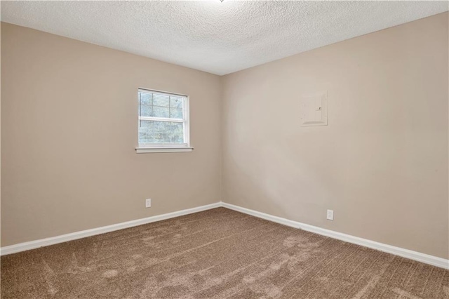 unfurnished room featuring a textured ceiling and carpet