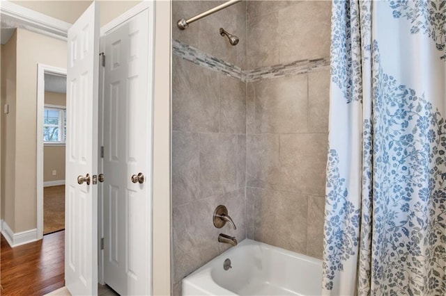 bathroom featuring wood-type flooring and shower / bathtub combination with curtain