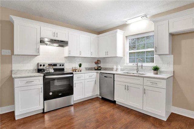 kitchen featuring appliances with stainless steel finishes, dark hardwood / wood-style floors, decorative backsplash, white cabinets, and sink