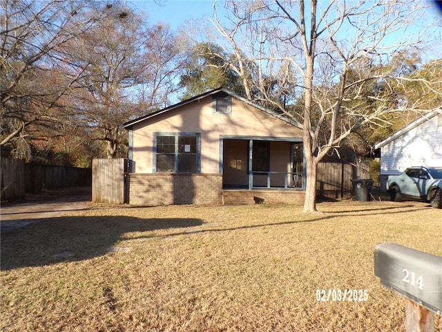 single story home featuring a sunroom and a front yard