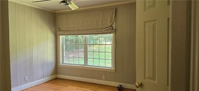 spare room featuring ceiling fan, ornamental molding, a healthy amount of sunlight, and light hardwood / wood-style flooring