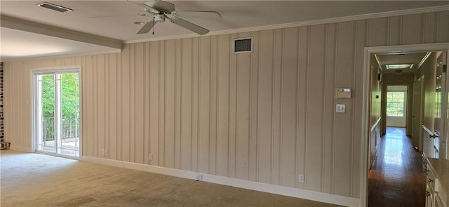 empty room featuring crown molding, ceiling fan, and dark colored carpet