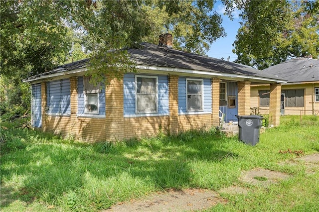 view of property exterior featuring entry steps, a chimney, and brick siding