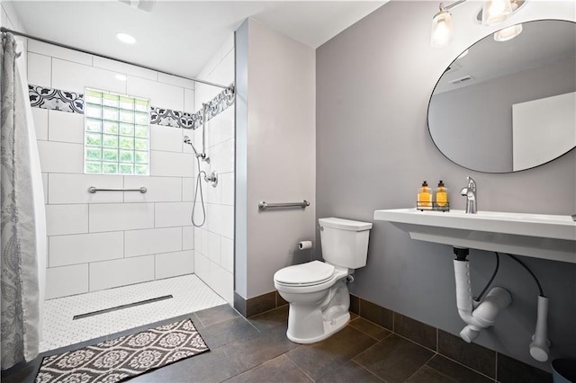 17714 Horseneck Rd, Bay Minette, AL 36507 - bathroom featuring toilet, a tile shower, recessed lighting, and baseboards