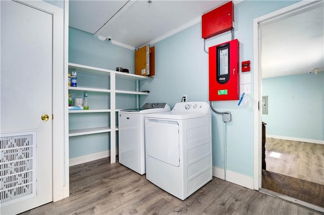 17714 Horseneck Rd, Bay Minette, AL 36507 - clothes washing area with wood finished floors, laundry area, ornamental molding, washing machine and dryer, and baseboards
