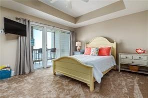 bedroom featuring carpet flooring, access to exterior, ceiling fan, and a tray ceiling