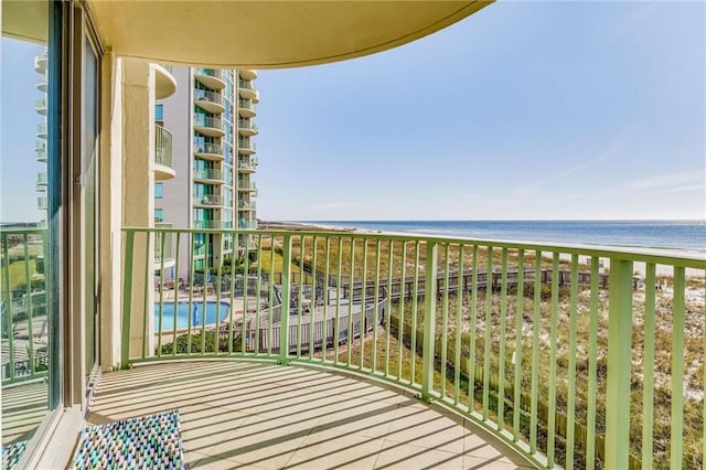 balcony featuring a water view and a view of the beach