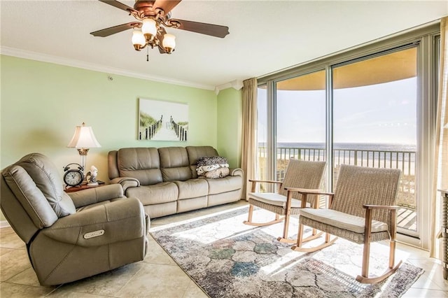 living room with a water view, ceiling fan, ornamental molding, light tile patterned floors, and a wall of windows