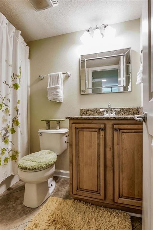 bathroom with vanity, a textured ceiling, and toilet