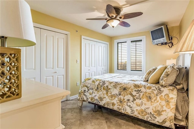 bedroom with two closets, ceiling fan, and light tile patterned flooring