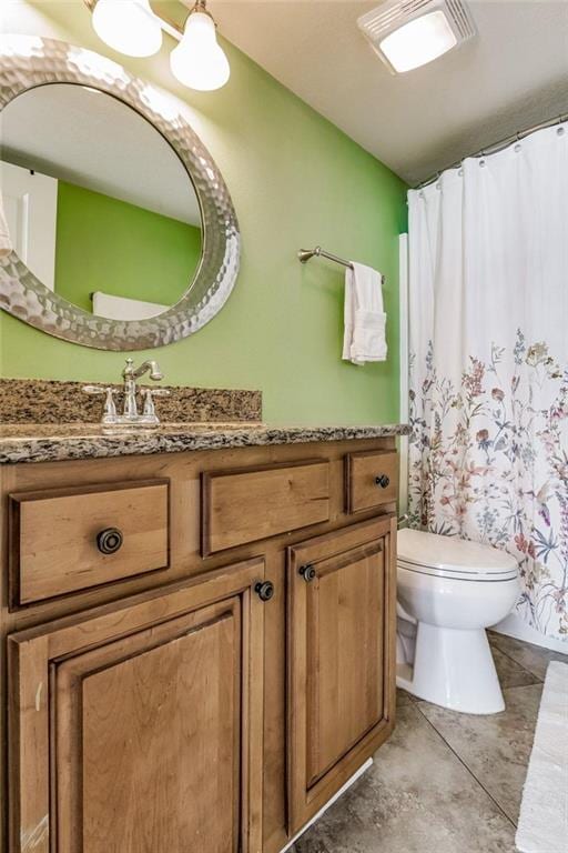 bathroom featuring tile patterned flooring, vanity, and toilet