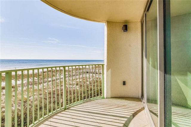 balcony with a water view and a beach view