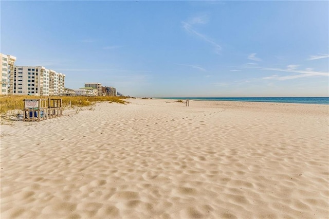 view of community with a water view and a beach view