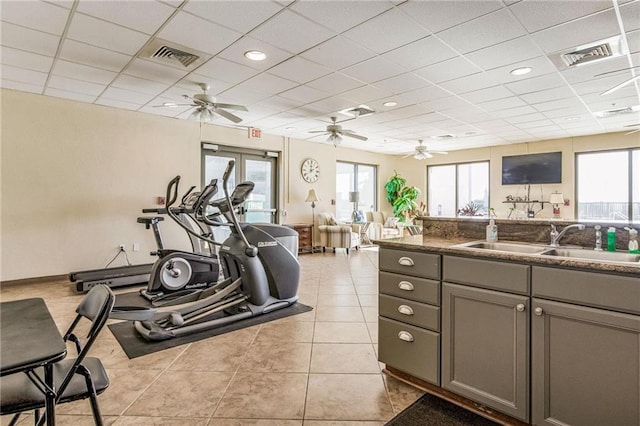 interior space with plenty of natural light, a drop ceiling, light tile patterned floors, and sink