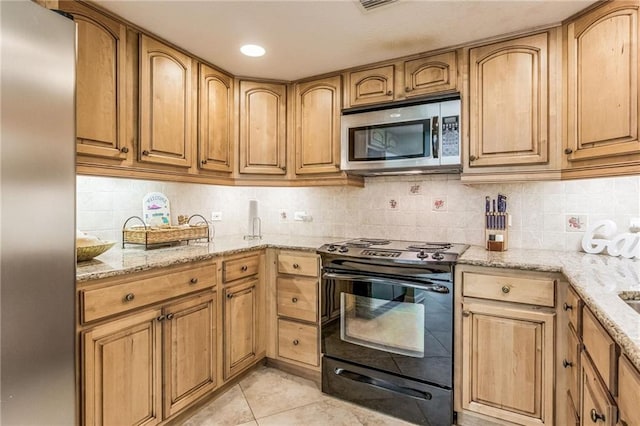 kitchen featuring backsplash, light stone counters, light tile patterned floors, and stainless steel appliances