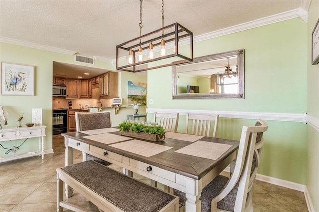 dining space with light tile patterned flooring, a textured ceiling, and ornamental molding