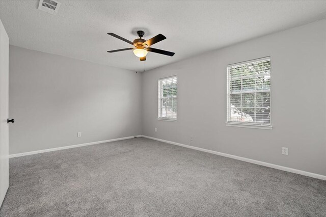 empty room featuring ceiling fan, carpet floors, and a textured ceiling