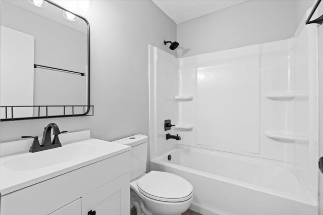 full bathroom with toilet, vanity, and washtub / shower combination