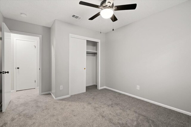 unfurnished bedroom featuring ceiling fan, light colored carpet, and a closet