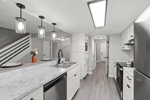 kitchen with appliances with stainless steel finishes, white cabinetry, pendant lighting, and sink