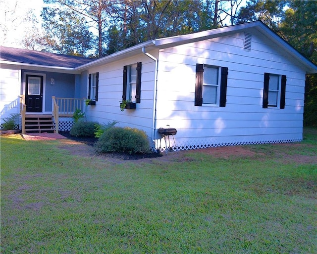 view of side of home with a yard